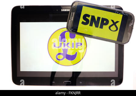 Die UKIP und SNP-Logos auf den Bildschirmen der ein Tablet und Smartphone vor einem weißen Hintergrund angezeigt. Stockfoto