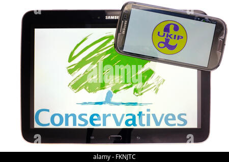 Die UKIP und konservative Logos auf den Bildschirmen der ein Tablet und Smartphone vor einem weißen Hintergrund angezeigt. Stockfoto