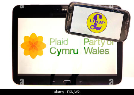 Das Plaid Cymru und UKIP-Logos auf den Bildschirmen der ein Tablet und Smartphone vor einem weißen Hintergrund angezeigt. Stockfoto