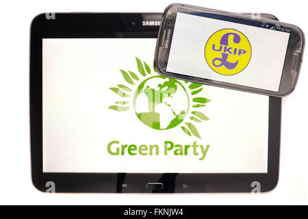 Die grüne Partei und die UKIP Logos auf den Bildschirmen der ein Tablet und Smartphone vor einem weißen Hintergrund angezeigt. Stockfoto