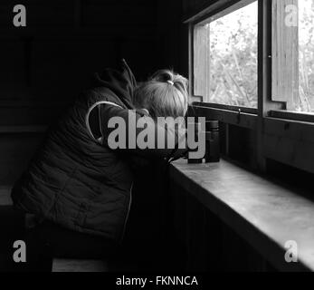 Verschlafene junge Frau in einem Versteck Vogelbeobachtung mit ihrem Fernglas nach einem sehr langen Tag. Juni 2015 Stockfoto