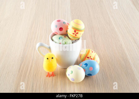 Ostern, kleine Küken und gefärbten Eiern in eine Kaffeetasse Stockfoto