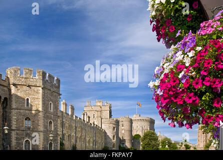 Windsor Castle, die Flagge der Royal Standard mit hängenden Korb Blumen im Vordergrund Windsor Berkshire UK Stockfoto