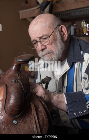 Ein Sattel, der von einem erfahrenen Handwerker repariert wird. Stockfoto