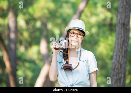 Schöne asiatische Mädchen lächelnd mit Retro-Kamera fotografieren, Outdoor-Reisen Stockfoto