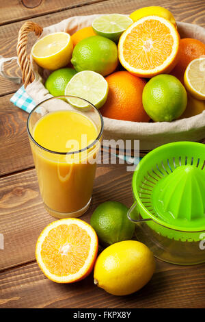 Zitrusfrüchte und ein Glas Saft. Orangen, Limetten und Zitronen Stockfoto