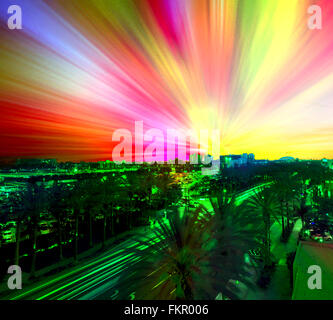 Bunte Streifen Himmel in den Farben des Regenbogens mit Streifen Verkehr unten auf stark befahrenen Straße. Abstrakte veränderte Foto. Stockfoto