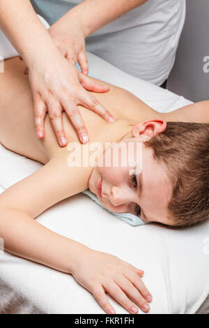 Masseurin massiert kleiner Junge zurück Stockfoto