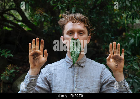 Kaukasischen Mann mit schmutzigen Händen und Blatt Stockfoto