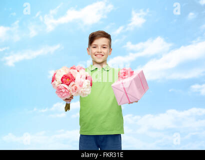 fröhlicher Junge hält Blume Haufen und Geschenk-box Stockfoto