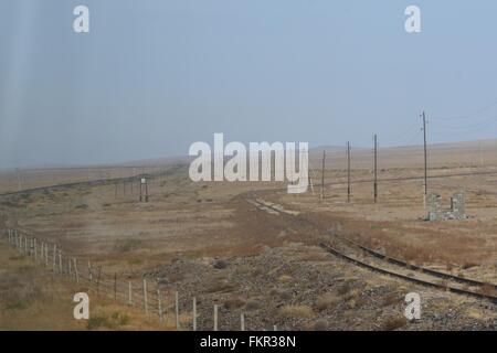 Endlosigkeit und karge Landschaft der Transsibirischen Eisenbahn Kreuzung der Mongolei in der Steppe - Blick aus dem Fenster Stockfoto