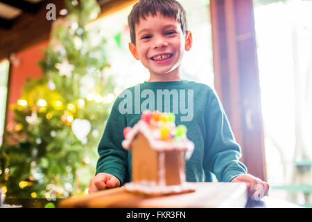 Gemischte Rassen junge lächelnd mit Lebkuchen-Haus Stockfoto