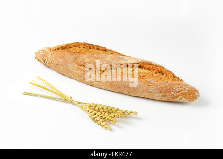 frisch gebackene französische Baguette und Haufen von Reifen Ohren auf weißem Hintergrund Stockfoto