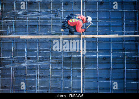 Kaukasische Arbeiter Nagelung Bretter auf Baustelle Stockfoto