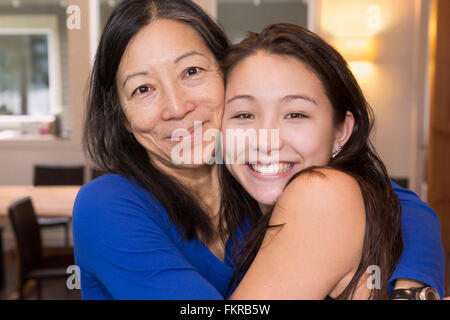 Mutter und Tochter umarmt im Innenbereich Stockfoto