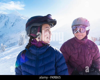 Mutter und Tochter tragen Skiausrüstung auf verschneiten Bergen Stockfoto