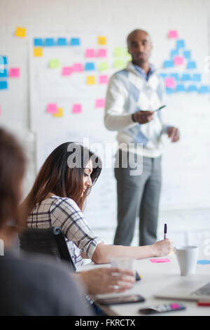 Business-Leute, die Schreiben von Notizen im Büro treffen Stockfoto