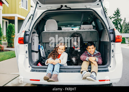 Gemischte Rassen Kinder sitzen mit Hund im Auto Luke Stockfoto