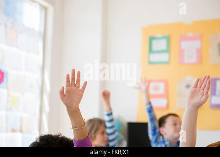 Studenten, die Hände im Klassenzimmer Stockfoto