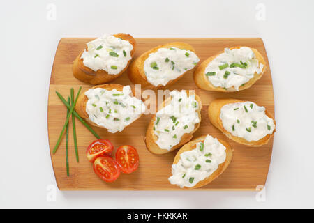 knusprige Croutons mit Schnittlauch zu verbreiten, auf Holzbrett Stockfoto