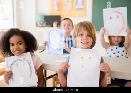 Studenten zeigen Zeichnungen im Klassenzimmer Stockfoto