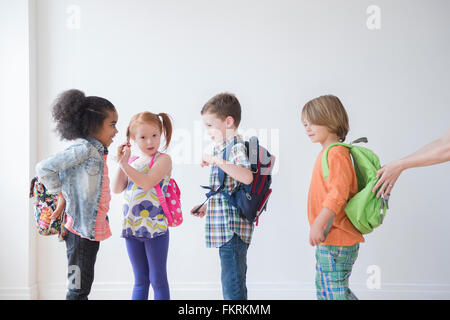 Schüler tragen Rucksäcke im Klassenzimmer Stockfoto