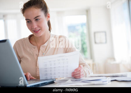 Gebürtige amerikanische Frau, die Zahlung von Rechnungen auf computer Stockfoto