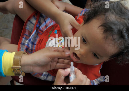 Ein Kind empfangen Tropfen der Polio-Schluckimpfung. Nach deklarierten poliofrei von World Health Organization Beamten im Jahr 2014, ist Indonesien nationalen Polio Impfwoche Beobachtung, durch schwört auf Millionen von Kindern zu impfen. Das erweiterte Masse Immunisierung Laufwerk gegen Polio und Masern begann gleichzeitig. Polio-Impfung-Laufwerk zielt auf Kinder im Alter von 9 bis 59 Monate alt war, und dass für Masern Säuglinge neun Monate bis 59 Monat alt. (Foto von Agung Samosir / Pacific Press) Stockfoto