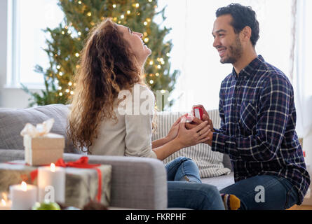 Mann schlägt vor, Freundin auf sofa Stockfoto