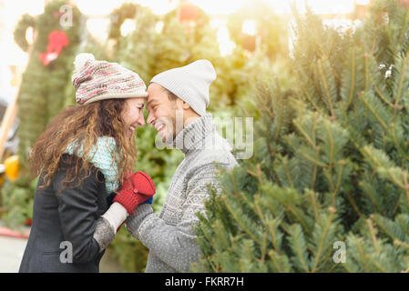 Paar umarmt Christmas Tree Farm Stockfoto