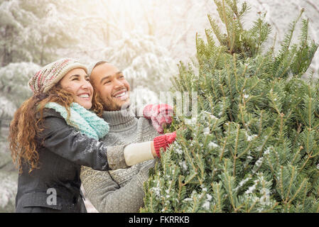 Paar umarmt Christmas Tree Farm Stockfoto