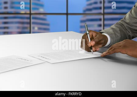 Afroamerikanischen unterzeichnet Dokument im Büro. Stockfoto