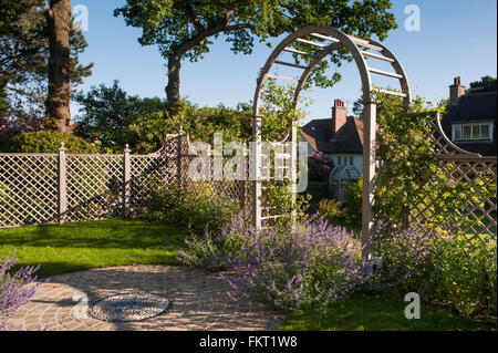 Mosaikkunst, Spalier Zaun und Bogen mit blauen Himmel und Sonne - schöne, traditionelle, gepflegten Garten, Burley in Wharfedale, Yorkshire, England. Stockfoto