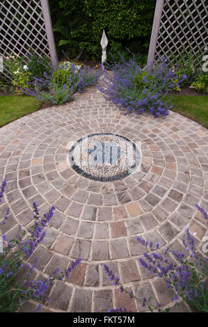 Kopfsteinpflaster Mosaik, dekorative Steinpflaster, Pflanzen, Skulpturen und Rankgitter in Garten entworfen, landschaftlich, Burley in Wharfedale, Yorkshire, England. Stockfoto