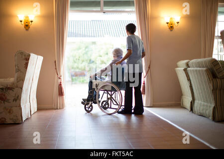 Krankenschwester drängen Patienten im Rollstuhl Stockfoto