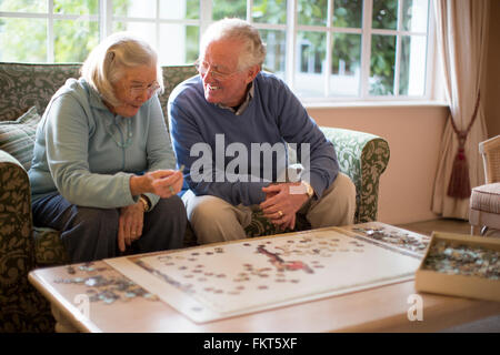 Älteres Ehepaar auf Sofa Lösung puzzle Stockfoto