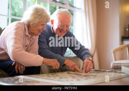 Älteres Ehepaar auf Sofa Lösung puzzle Stockfoto