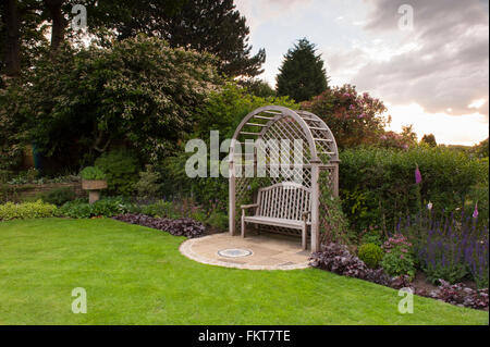 Holz- gitter Sitz Laube, Mosaik Kunst, Rasen & Sommer Grenze Pflanzen in schönen, traditionellen, gestaltet, angelegten Garten - West Yorkshire, England. Stockfoto