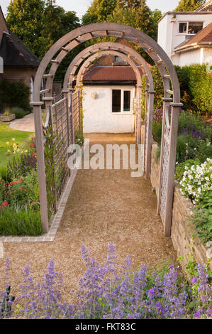 Blick entlang ein Weg, Tunnel Laube & Grenze - vor kurzem entwickelt und landschaftlich, traditionellen Garten, Burley in Wharfedale, West Yorkshire, England. Stockfoto