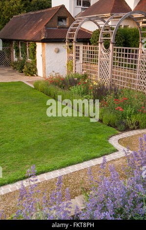 Vor kurzem entwickelt und landschaftlich, einen schönen, traditionellen Garten mit Laube und Grenze, im Sommer - Burley in Wharfedale, West Yorkshire, England. Stockfoto