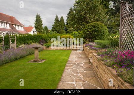 Vor kurzem entwickelt und landschaftlich, einen schönen, traditionellen Garten mit bunten Rändern, im Sommer - Burley in Wharfedale, West Yorkshire, England. Stockfoto