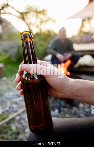 Hand hält Bierflasche, Nahaufnahme Stockfoto