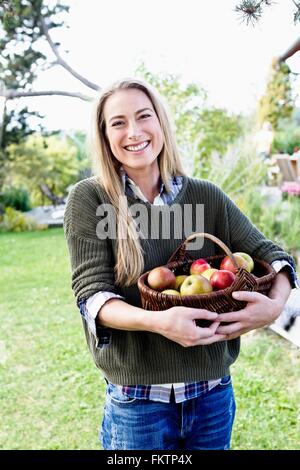 Mitte Erwachsene Frau mit Korb Äpfel Porträt Stockfoto