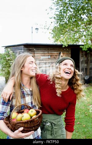 Zwei Frauen im Garten mit Korb Äpfel, lachen Stockfoto