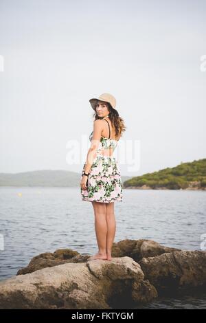 Frau auf Felsen am Meer Stockfoto