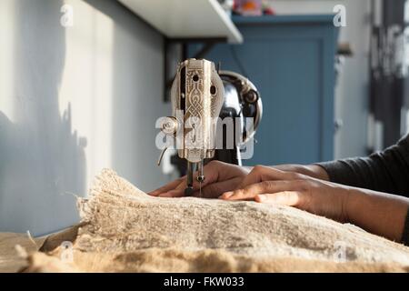 Nahaufnahme eines Womans Hände Textilien auf Vintage Nähmaschine nähen Stockfoto