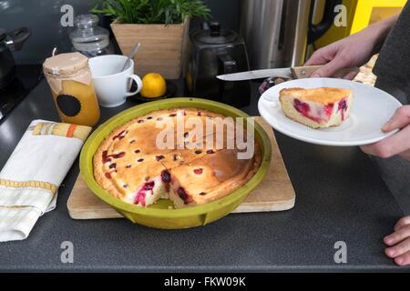 Weibliche Hände Halteplatte mit gebackenen Kuchen am Küchentisch Stockfoto