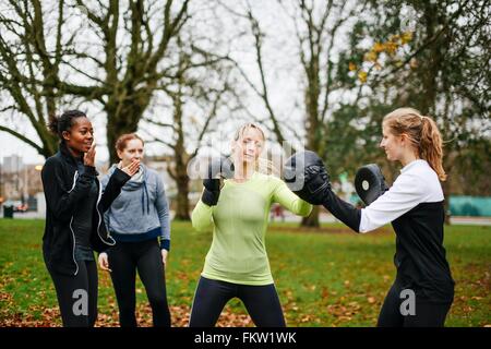 Boxerinnen Stanzen einander im park Stockfoto