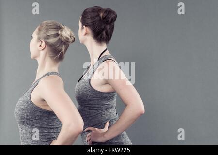 Junge Frauen praktizieren Yoga, grauen Hintergrund Stockfoto