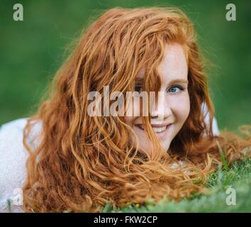 Junge Frau liegt auf dem Rasen Stockfoto